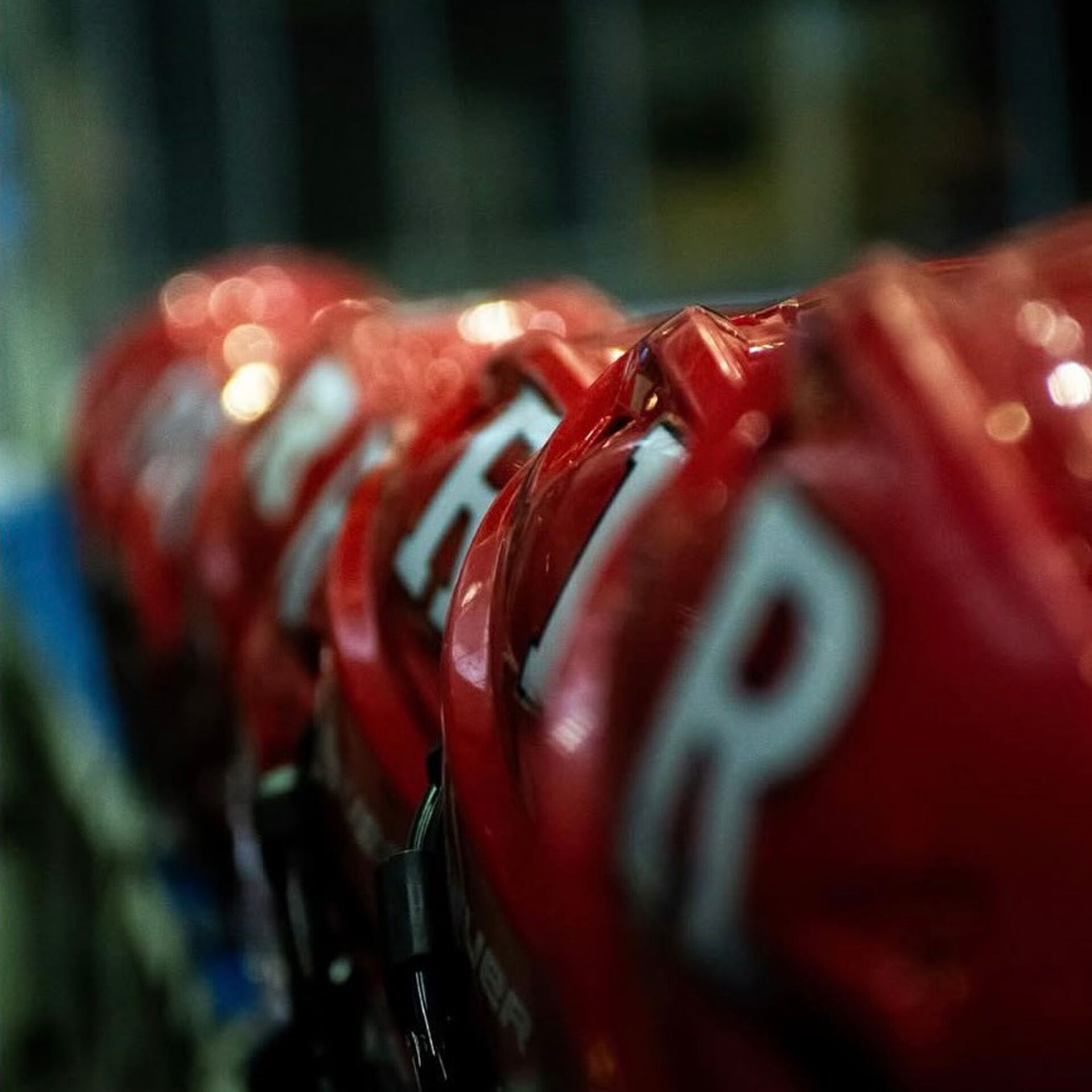 A row of scarlet Rutgers hockey helmets with white block R logos
